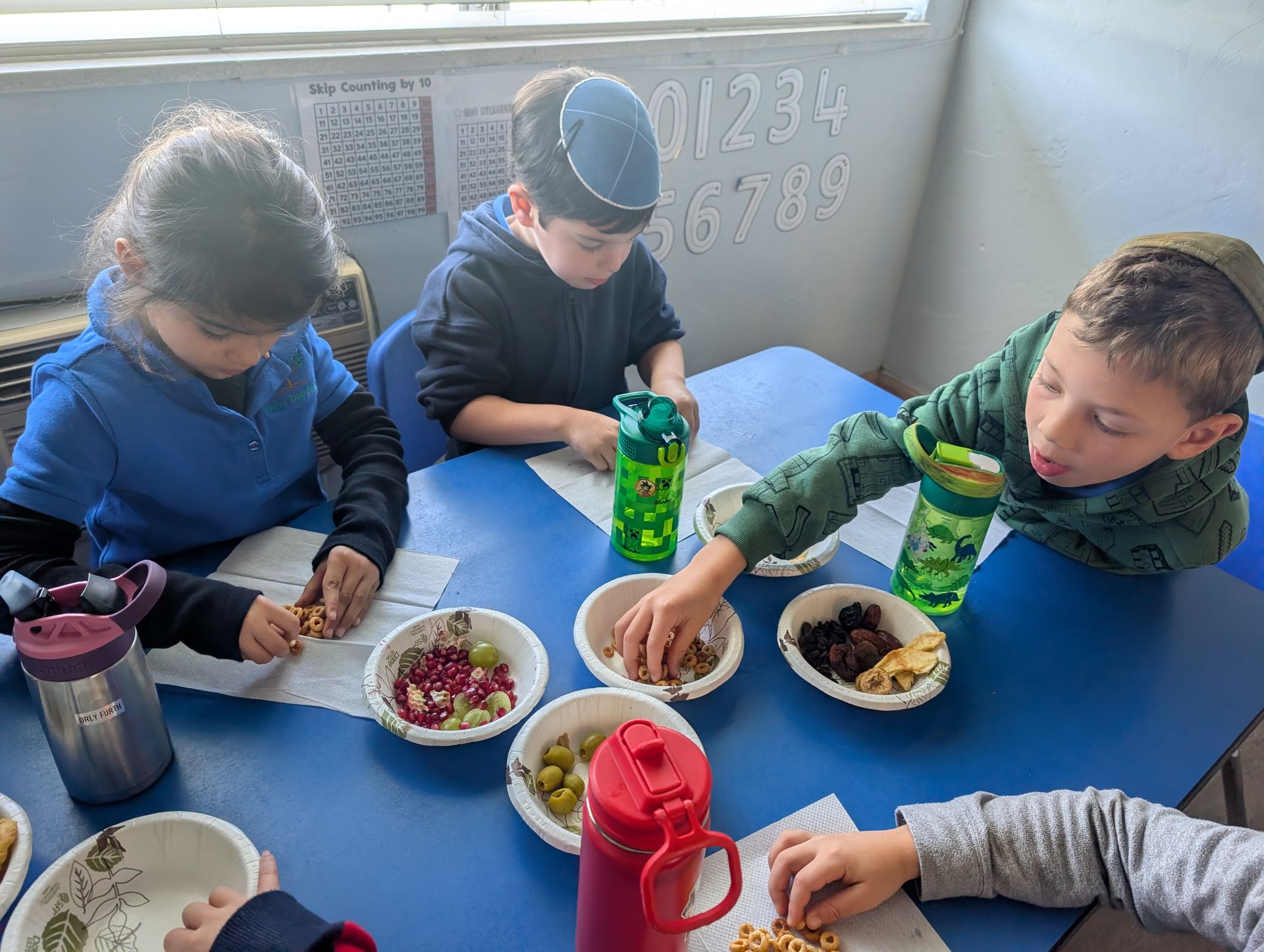 Students sharing fruit and nuts at a class table