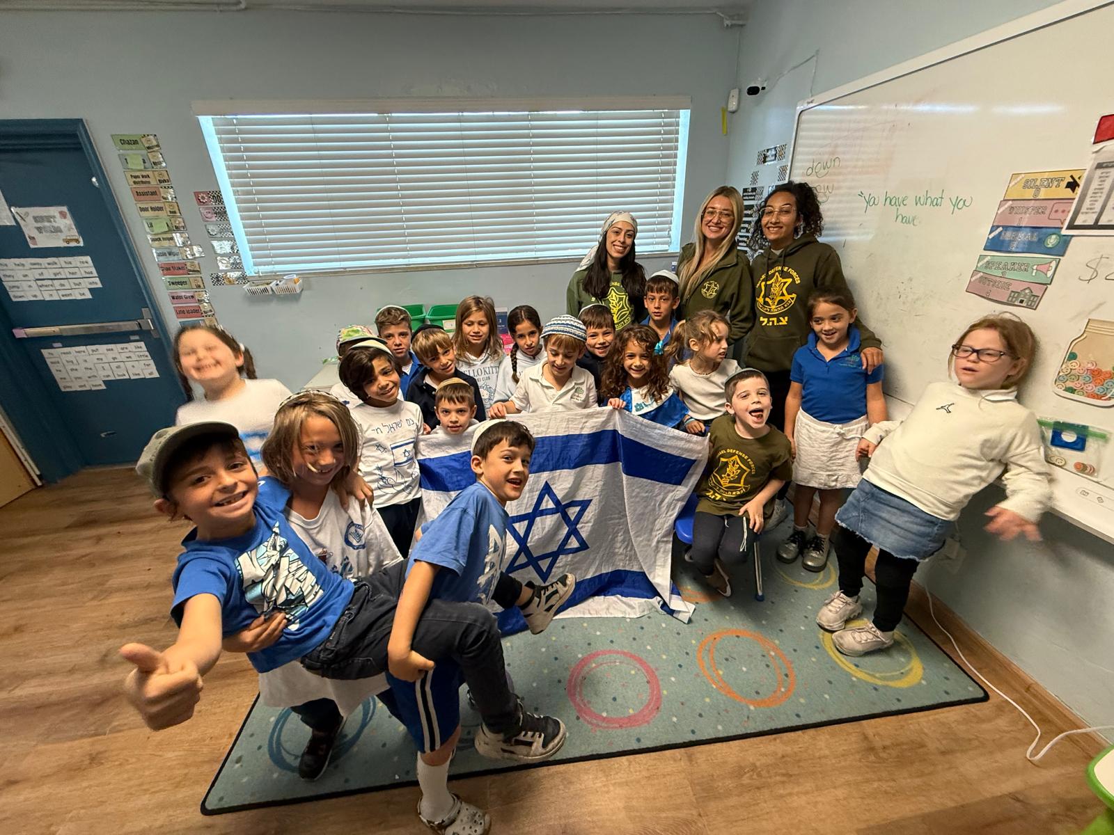 A class gathered around an Israeli flag